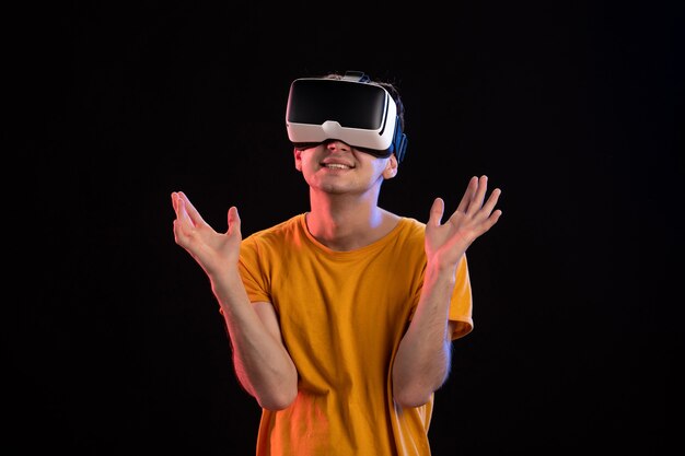 Portrait of young man wearing vr headset on a dark wall