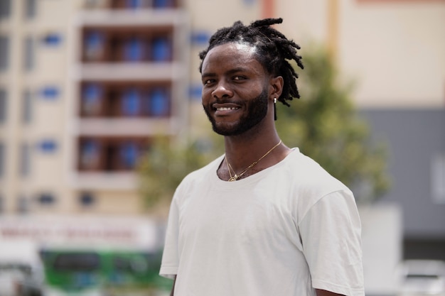 Portrait of young man with afro dreadlocks and white t-shirt outdoors