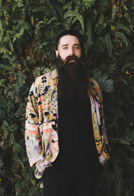 Portrait of a young man with long beard looking at camera