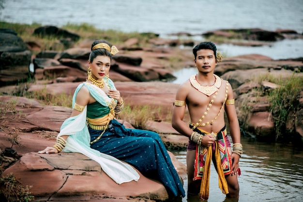 Free Photo portrait of young man and woman wearing beautiful traditional costume pose in nature in thailand