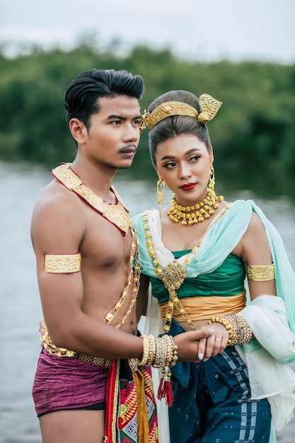 Free Photo portrait of young man and woman wearing traditional costume posing in nature in thailand