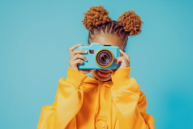 Free photo portrait of young person holding camera device for world photography day