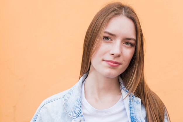 Portrait of young pretty woman against beige background