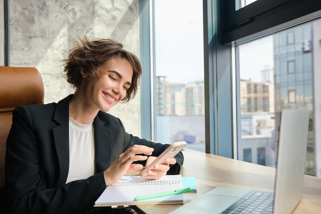 Free Photo portrait of young professional saleswoman businesswoman in suit sitting in office at her company