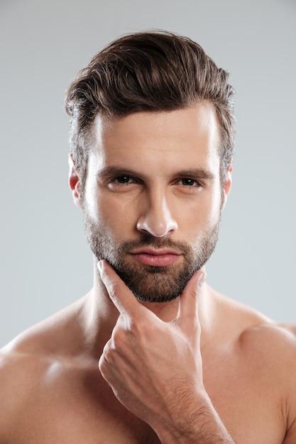 Free photo portrait of a young sexy naked man touching his chin