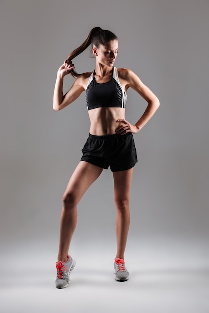 Portrait of a young slim fitness woman posing while standing