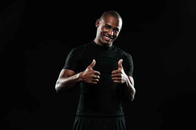 Portrait of a young smiling african sports man, showing thumbs up