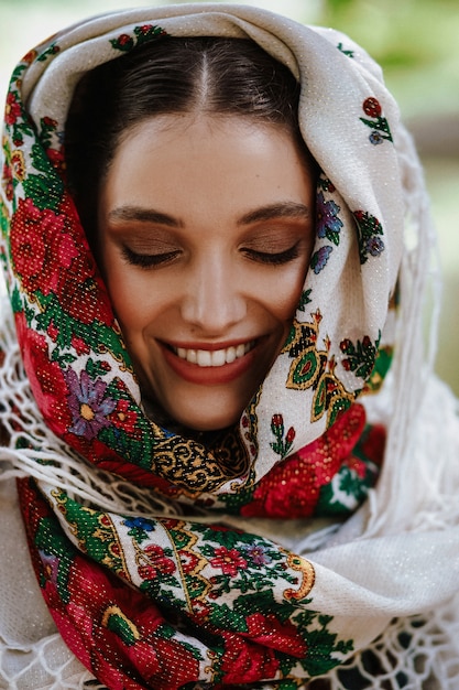 Free photo portrait of a young smiling woman in a traditional embroidered dress