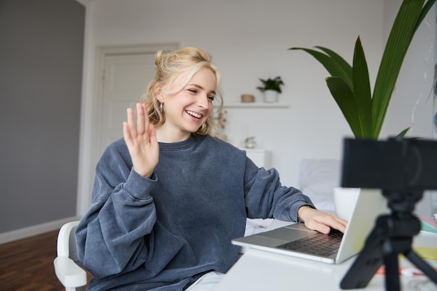 Free Photo portrait of young social media content creator woman sits in room with laptop and digital camera