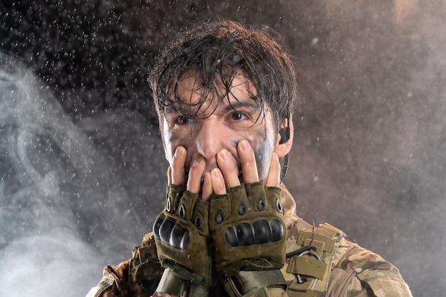 Free photo portrait of young soldier in uniform on dark wall