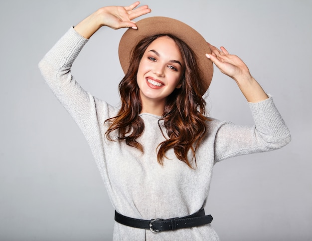 Portrait of young stylish laughing model in gray casual summer clothes in brown hat with natural makeup