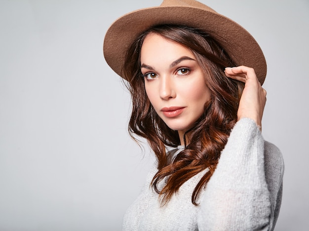 Portrait of young stylish laughing model in gray casual summer clothes in brown hat with natural makeup