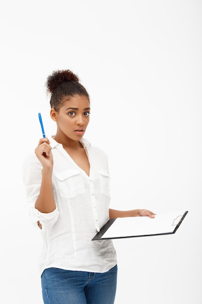 Portrait of young successful african business lady over white wall