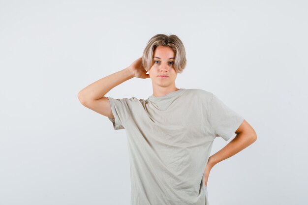 Portrait of young teen boy keeping hand behind head in t-shirt and looking confident front view