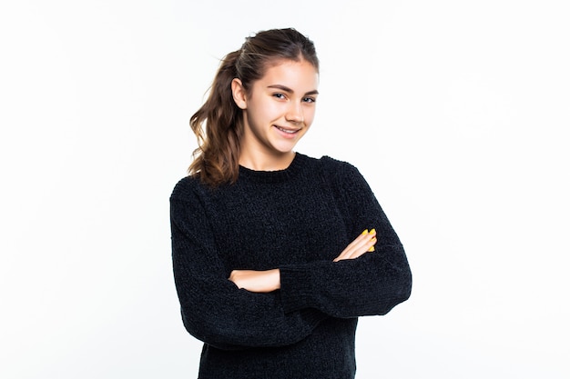 Portrait of young teen girl standing with folded hands over white wall