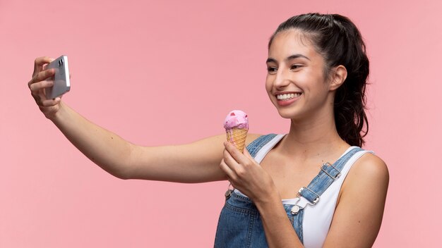 Portrait of young teenage girl taking a selfie while holding ice cream