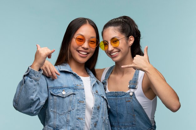 Portrait of young teenage girls with sunglasses showing call sign