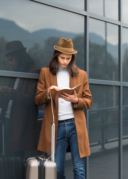 Free photo portrait of young traveler reading