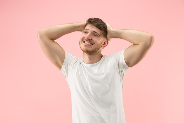 Portrait of young trendy man on pink background. Emotional expression.