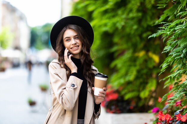 Portrait of young urban woman walking and talking on mobile phone on the street