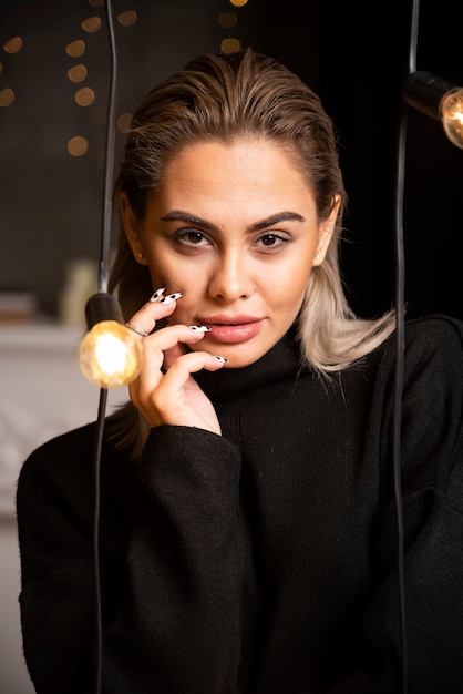 Portrait of young woman in black sweater standing and posing