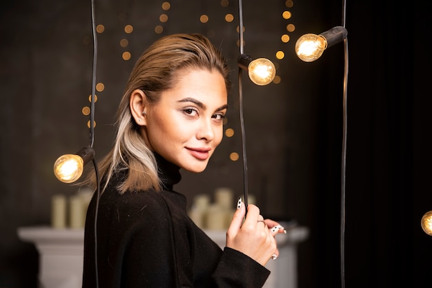 Portrait of young woman in black sweater standing and posing.