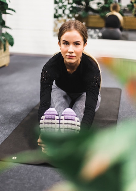 Portrait of a young woman doing stretching exercise