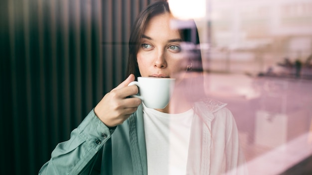 Portrait of a young woman enjoying coffee