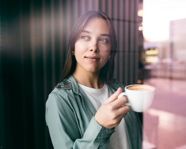 Portrait of a young woman enjoying coffee