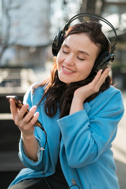 Portrait of young woman enjoying music outdoors