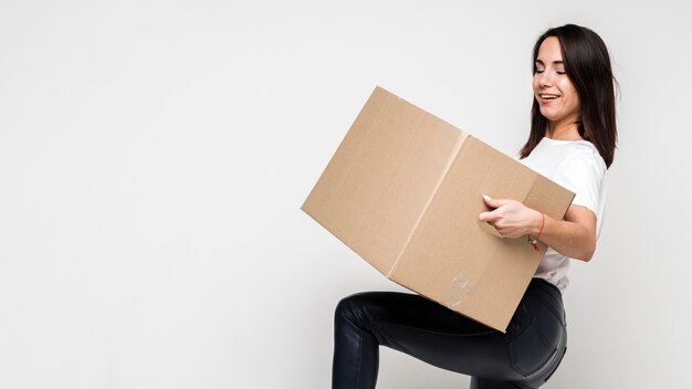 Portrait of young woman holding cardboard box