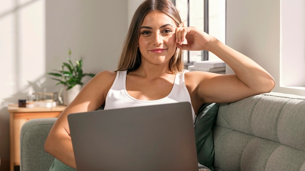 Portrait of young woman holding laptop