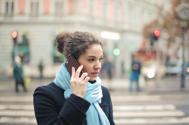 Free Photo portrait of young woman on the phone in the street