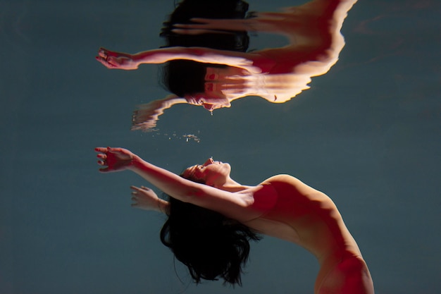 Portrait of young woman posing submerged underwater