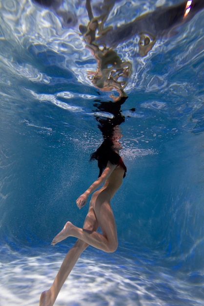 Free photo portrait of young woman posing submerged underwater