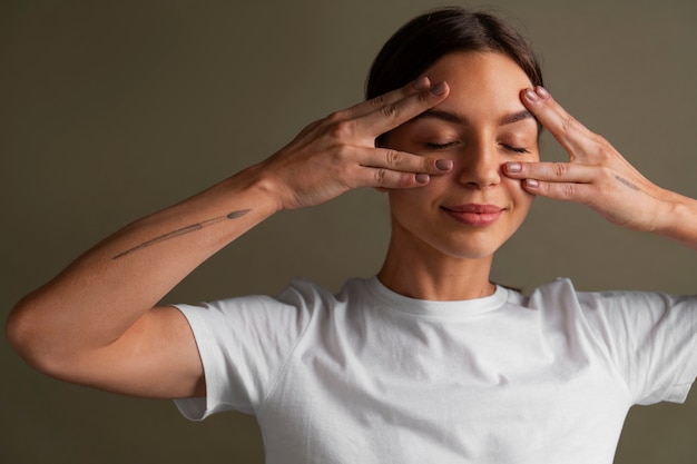 Portrait of young woman practicing facial yoga for youth