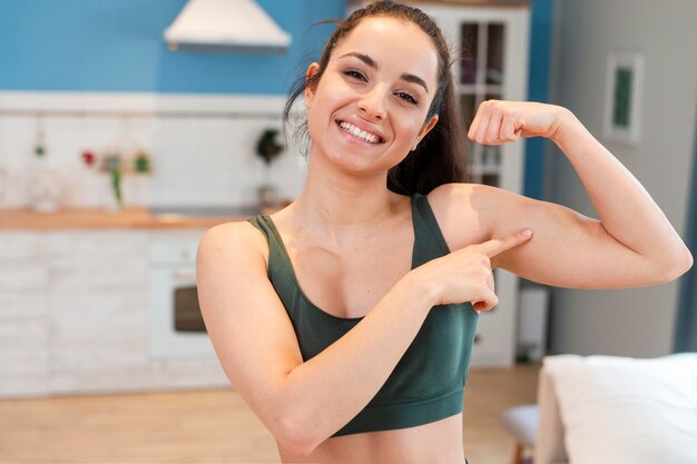 Portrait of young woman showing her muscles