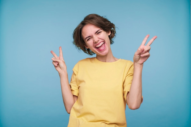 Portrait of a young woman showing the peace sign