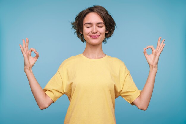 Portrait of a young woman showing the zen sign