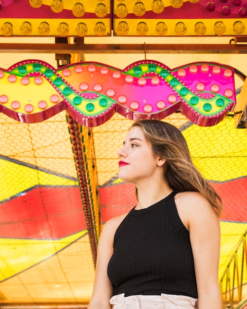 Portrait of young woman standing at illuminated tent