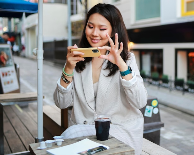 Portrait of young woman taking a photo of snack