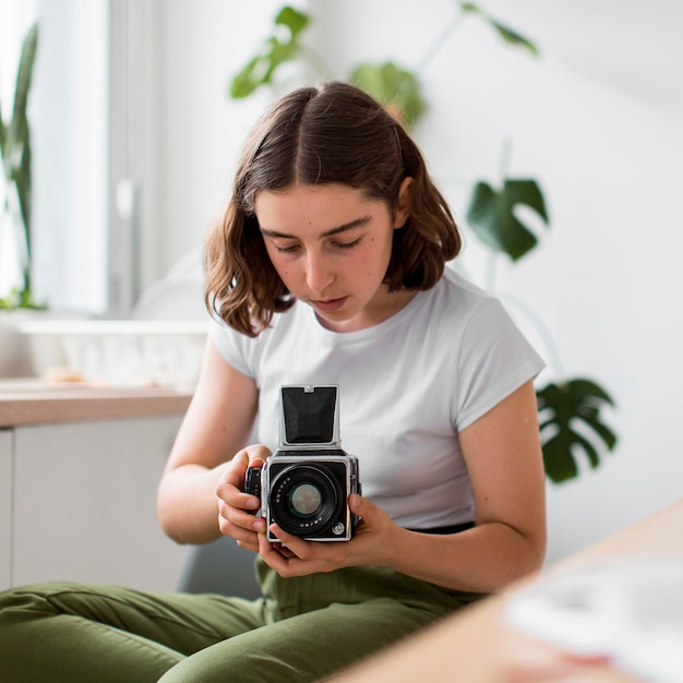 Free Photo portrait of young woman taking a photo with camera