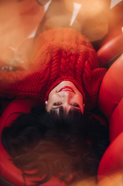 Portrait of a young woman in a warm knitted red sweater outside relaxes