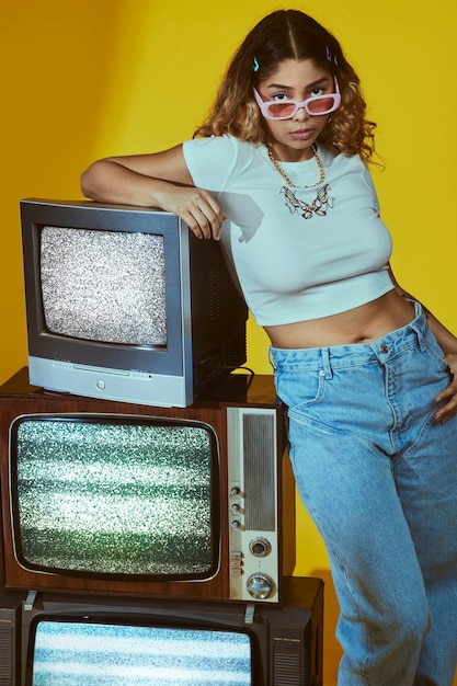 Portrait of young woman with 2000s fashion style posing with tv