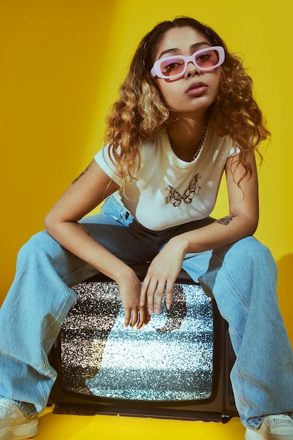 Portrait of young woman with 2000s fashion style posing with tv