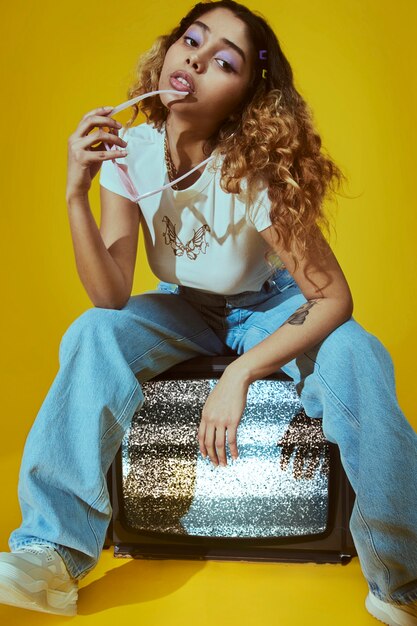 Portrait of young woman with 2000s fashion style posing with tv