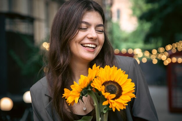 Portrait of a young woman with a bouquet of sunflowers