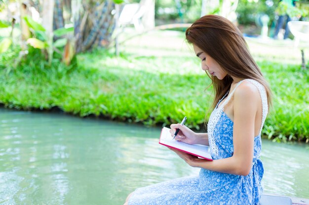 Portrait young woman with diary in park