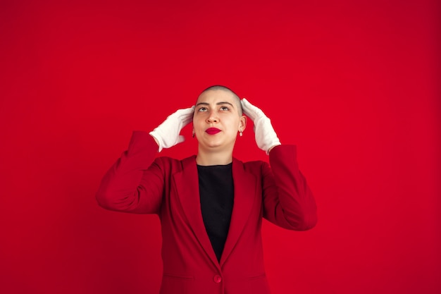 Portrait of young woman with freaky appearance on red wall