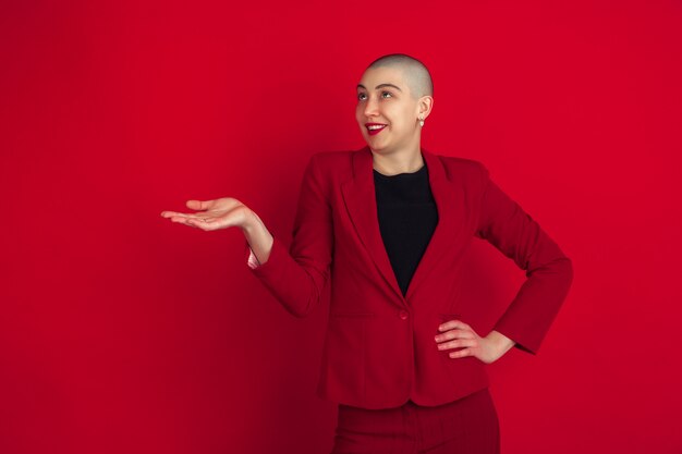 Portrait of young woman with freaky appearance on red wall